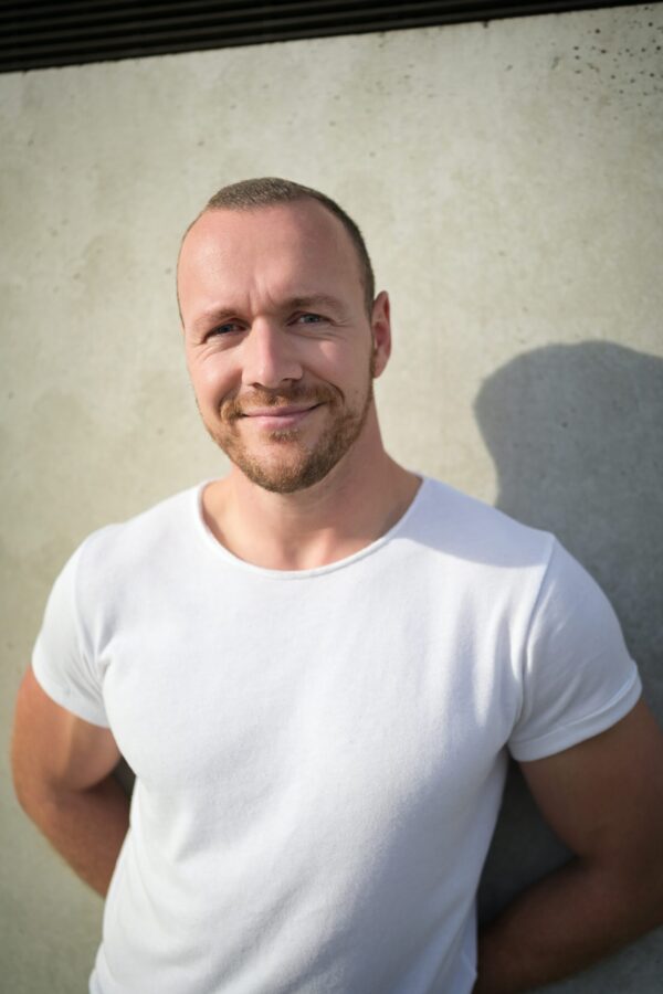 Männerportrait vor einer hellen Betonwand